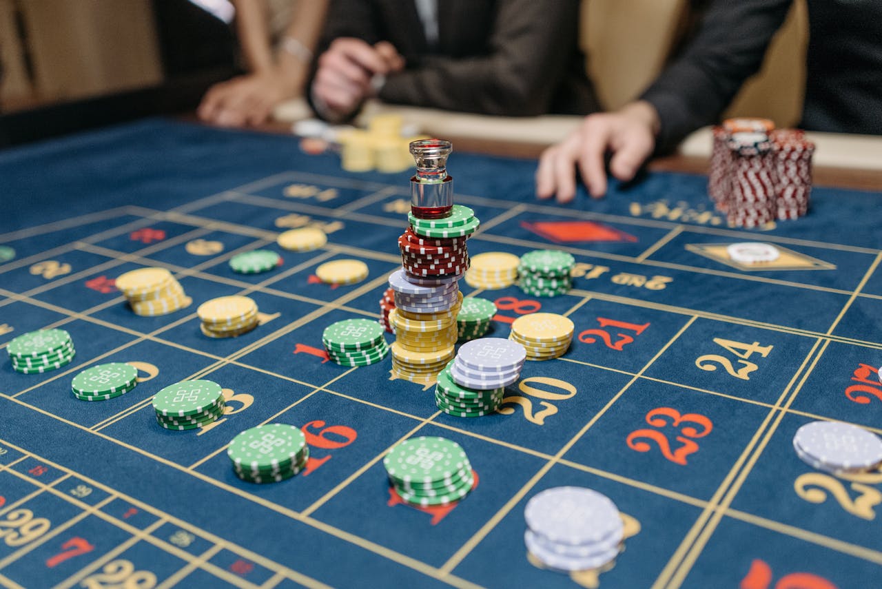 Home A casino table featuring stacked gaming chips and a roulette layout, suggesting gameplay.